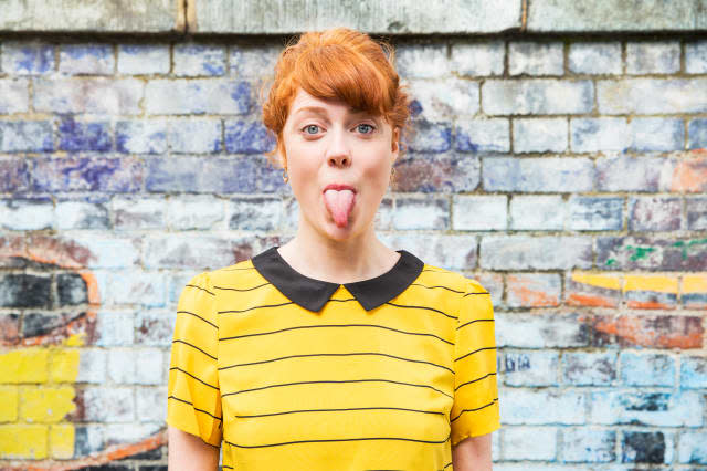 Young woman sticking tongue out.