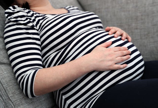 A pregnant woman lying on a sofa