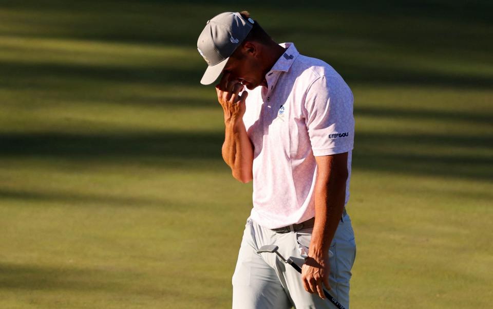 Bryson DeChambeau with his head in his hands on 15