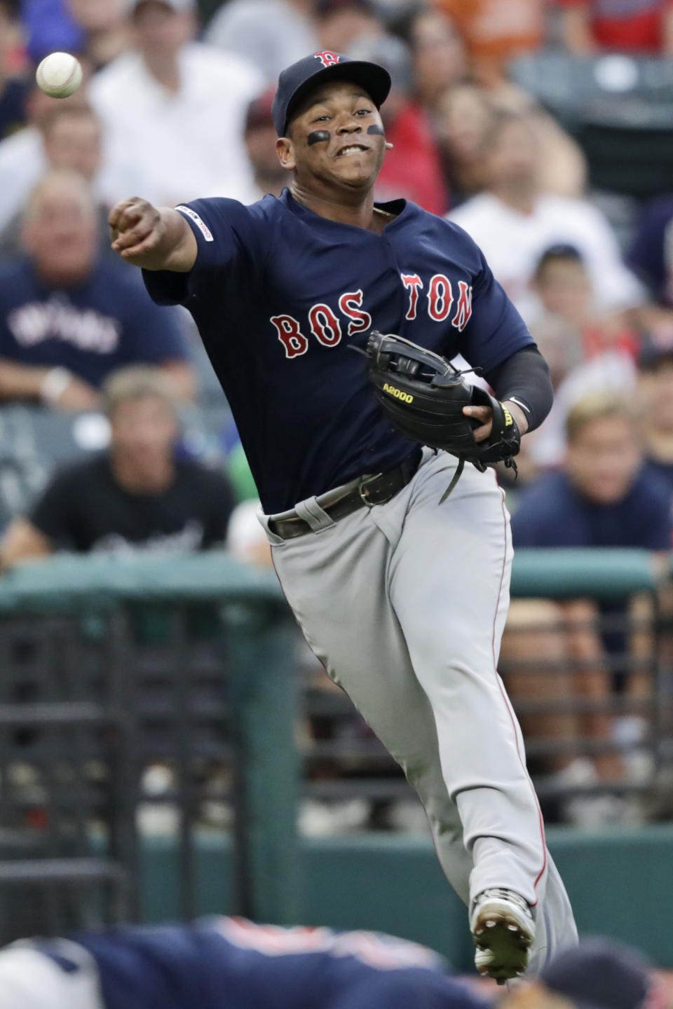 Boston Red Sox's Rafael Devers throws to first base but not in time to get out Cleveland Indians' Carlos Santana in the third inning of a baseball game, Monday, Aug. 12, 2019, in Cleveland. (AP Photo/Tony Dejak)