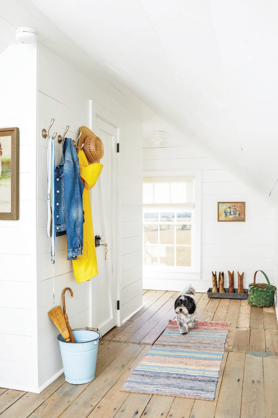 hallway with white shiplap walls and coat hooks