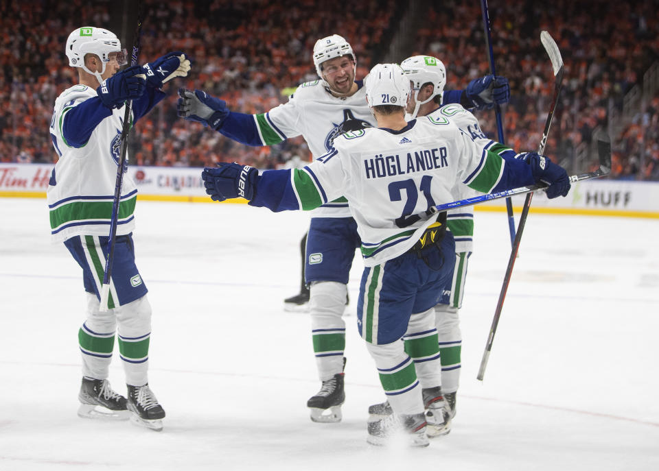Vancouver Canucks celebrate a goal against the Edmonton Oilers during the third period of an NHL hockey game Wednesday, Oct. 13, 2021, in Edmonton, Alberta. (Jason Franson/The Canadian Press via AP)