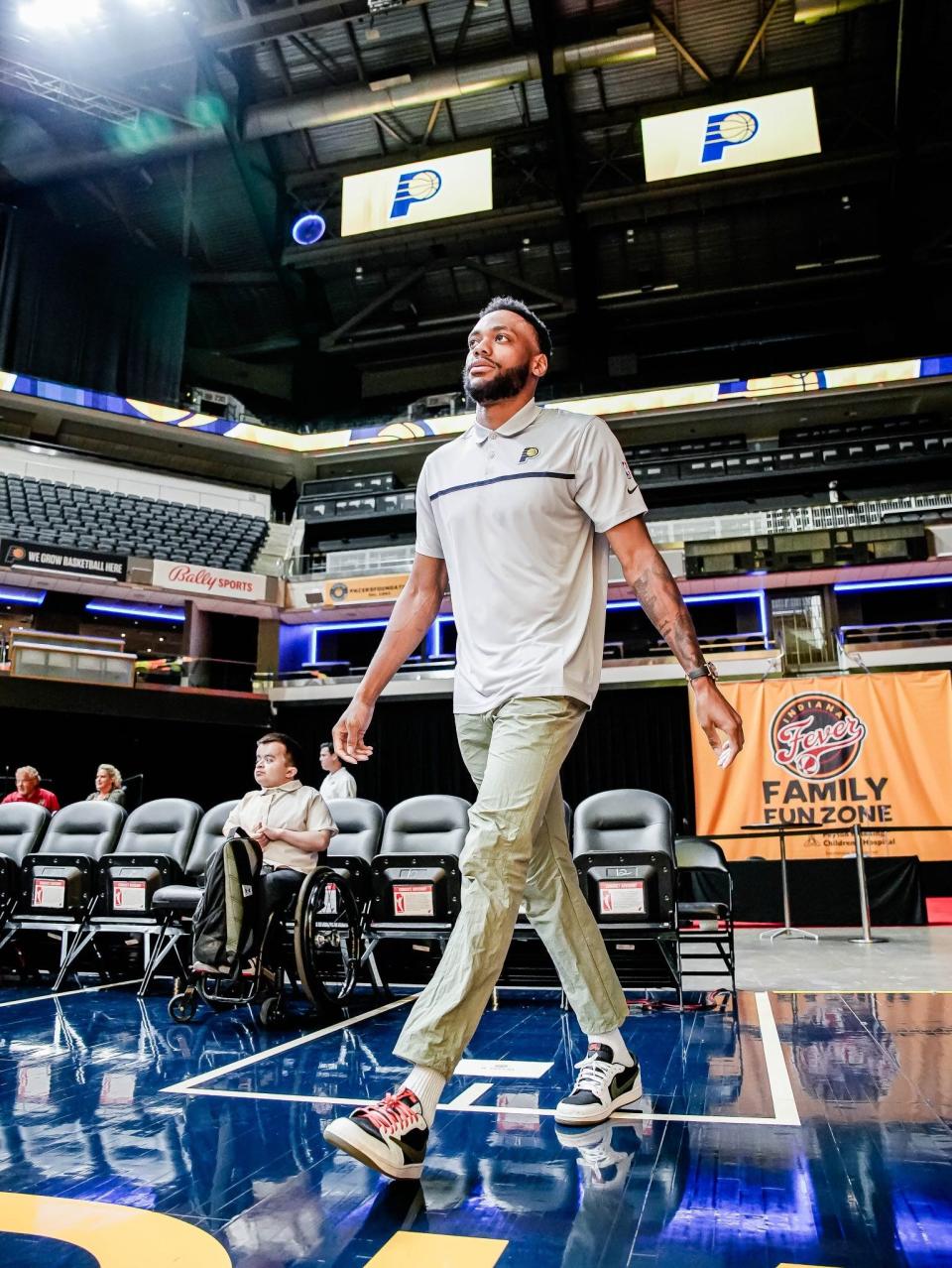 Alec Cabacungan (in the background) as Indiana Pacers player Bruce Brown walks onto the court at Gainbridge Fieldhouse. Cabacungan, a national television spokesperson for Shriners Hospitals for Children, was a Pacers intern this summer.