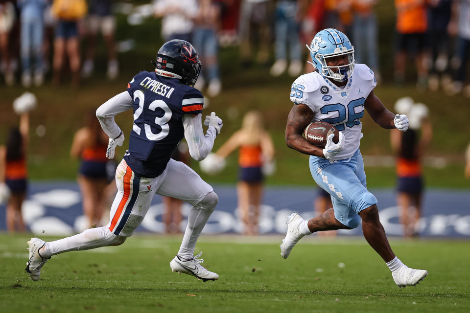 Nov 5, 2022; Charlottesville, Virginia, USA; North Carolina Tar Heels running back D.J. Jones (26) carries the ball as Virginia Cavaliers defensive back Fentrell Cypress II (23) defends during the second half at Scott Stadium. Mandatory Credit: Scott Taetsch-USA TODAY Sports