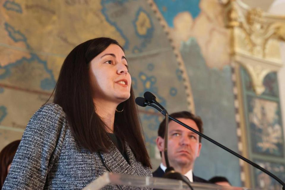 Rosa María Paya habla sobre su pader mientras el gobernador Ron DeSantis observa durante un acto de homenaje a las víctimas del comuicmos en la Torre de la Libertad de Miami, el lunes 9 de mayo de 2022.