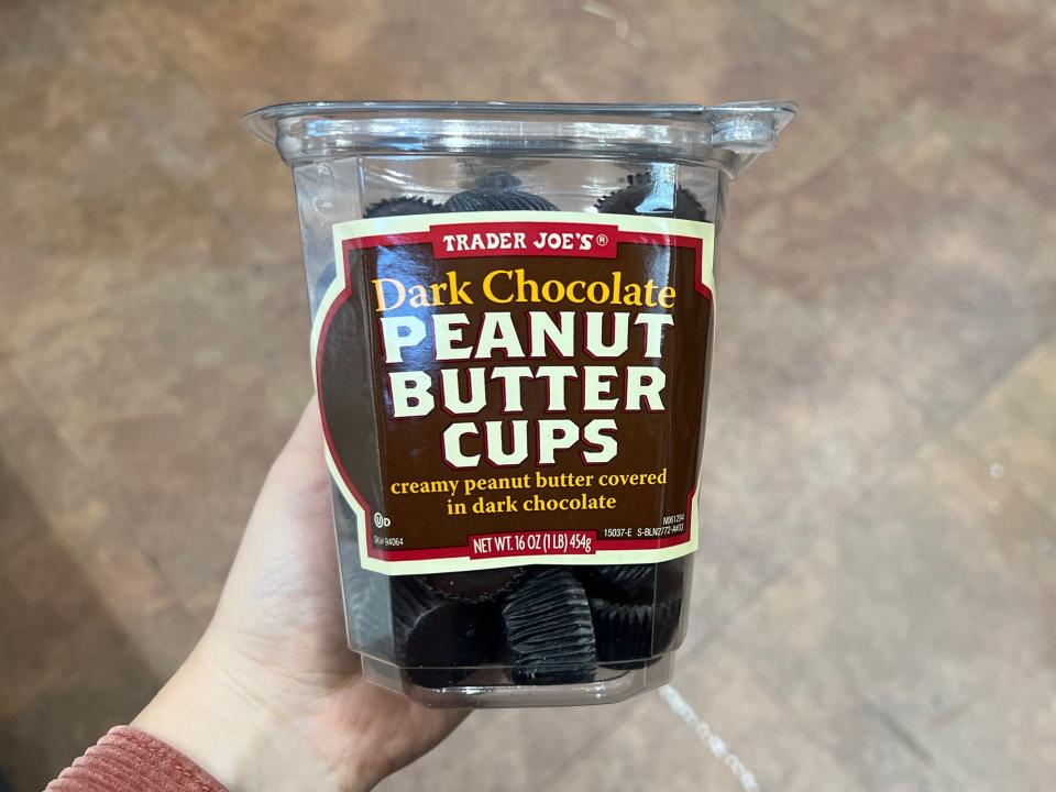The writer holds a container of Trader Joe's dark-chocolate peanut-butter cups