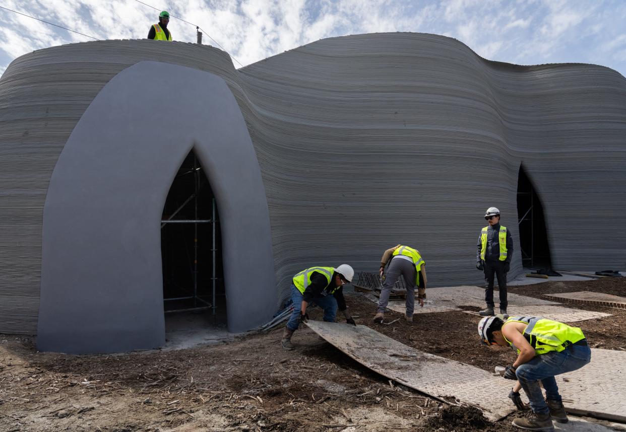 Workers wrap up construction Saturday on a 3D-printed building created by Icon in Austin. The 27-foot-tall building was built to test a new printer called Phoenix.