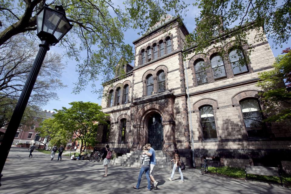 FILE - In this May 7, 2012 file photo, people walk past Sayles Hall on the campus of Brown University, in Providence, R.I. Brown placed a fundraising director on administrative leave in September 2019 following a report that accused him of participating in covering up disgraced financier Jeffrey Epstein's connections to the Massachusetts Institute of Technology Media Lab. (AP Photo/Steven Senne, File)