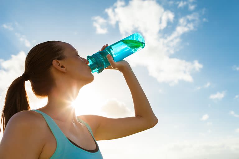 Young female drinking a bottle of water.