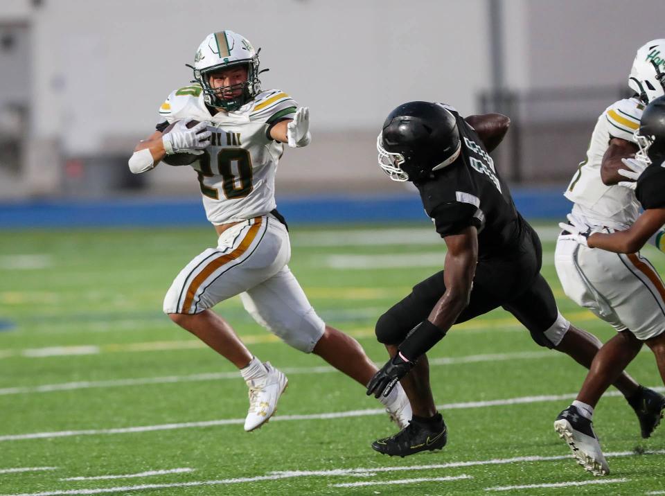 Savannah Country Day running back Hyers Holland readies to throw a stiff arm to Windsor Forest's Marquis Lonnon during the season opener on Thursday, August 17, 2023 at Savannah High Stadium.