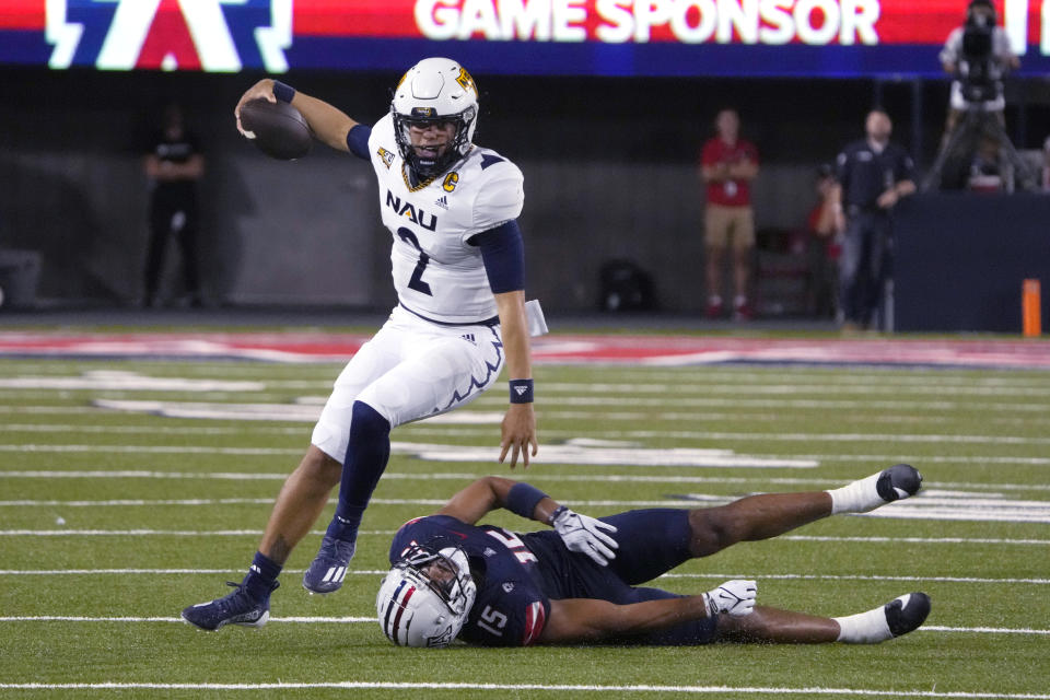 Northern Arizona quarterback Kai Millner gets away from Arizona linebacker Daniel Heimuli (15) during the first half of an NCAA college football game Saturday, Sept. 2, 2023, in Tucson, Ariz. (AP Photo/Rick Scuteri)