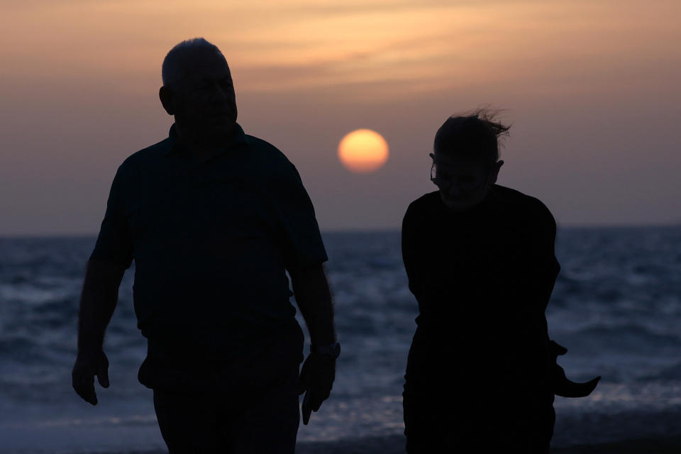 People walk during the sunset by the sea in Vlora, Albania, April 1, 2024. REUTERS/Florion Goga