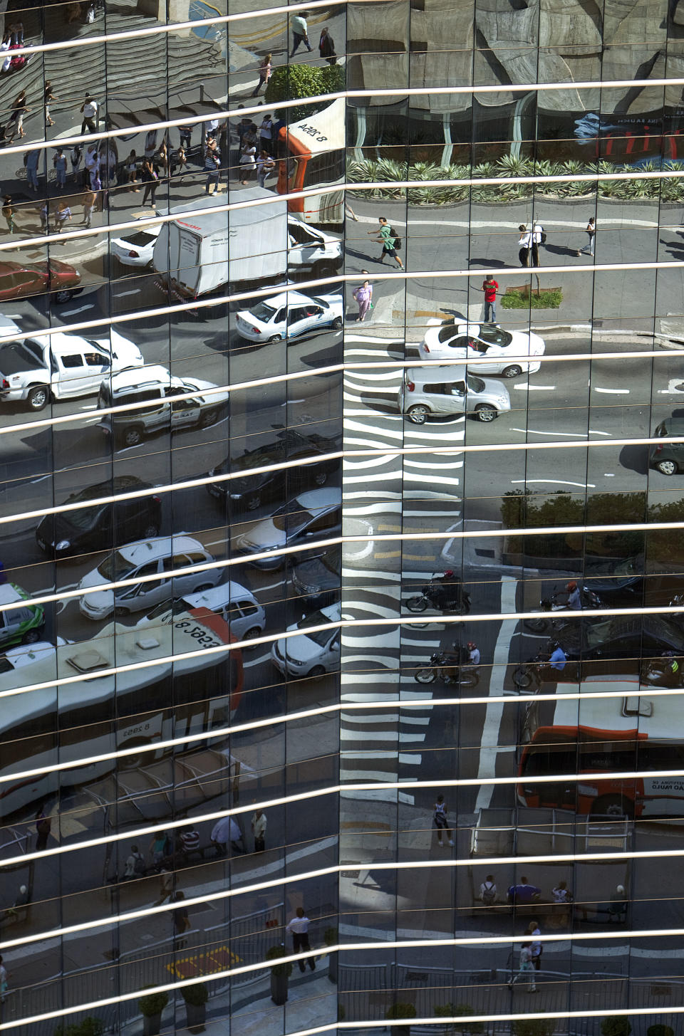 Vehicles are seen reflected on the windows of an office building in Sao Paulo, Brazil, Wednesday, March 14, 2012. A just-released report prepared by American consulting firm KPMG and France's Greater Paris Investment Agency shows that Sao Paulo now beats out New York as the top destination for foreign investments in the Americas. (AP Photo/Andre Penner)