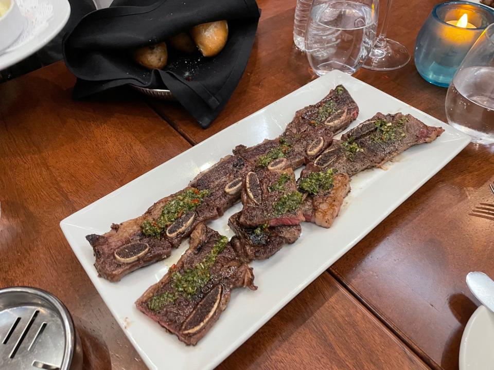 A plate of short ribs on a dining table.