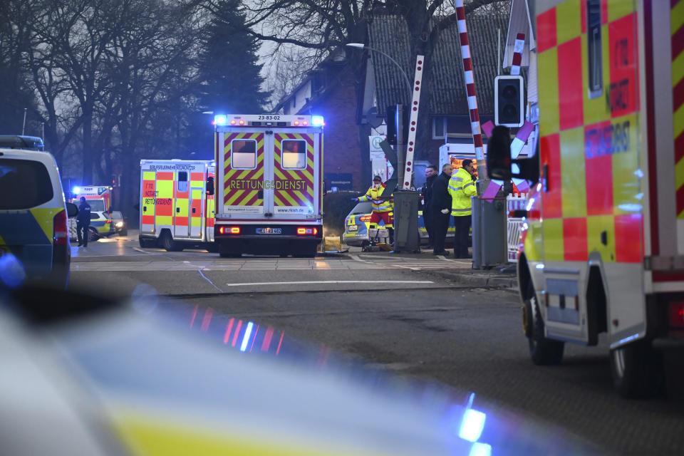 Police and rescue services are on duty at a level crossing near Brokstedt station in Brockstedt, Germany, Wednesday, Jan. 25, 2023. A man stabbed and wounded several people on a train in northern Germany on Wednesday before police detained him, and two of the victims died, German news agency dpa reported. (Jonas Walzberg/dpa via AP)