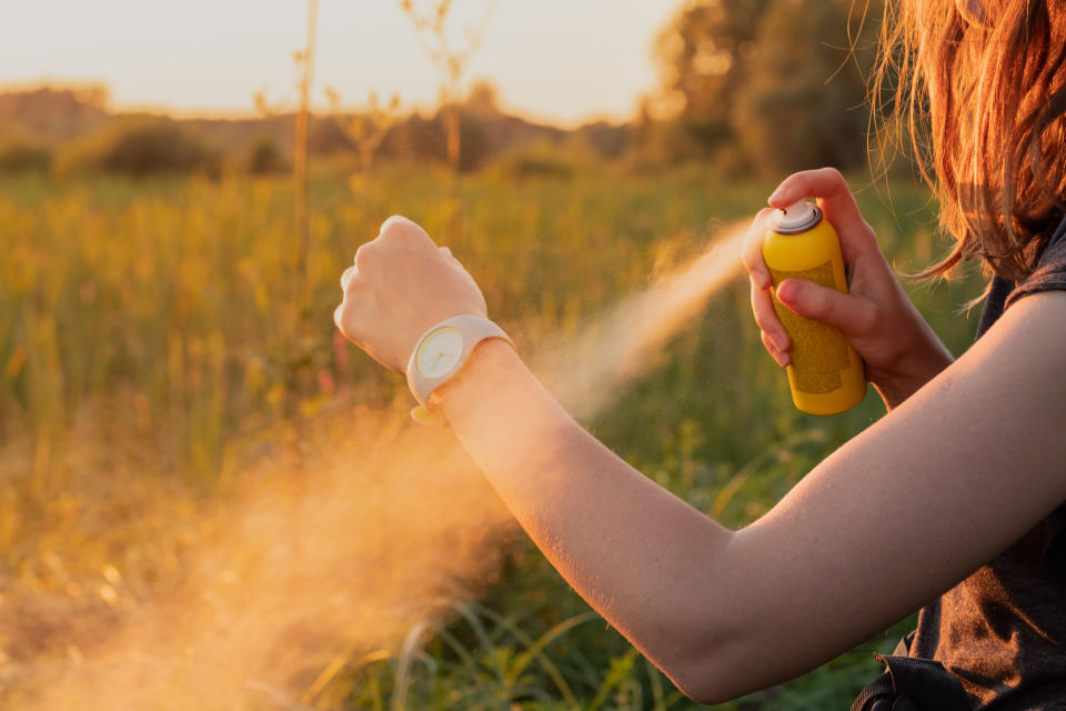 Man spraying insecticide on arm in field environment