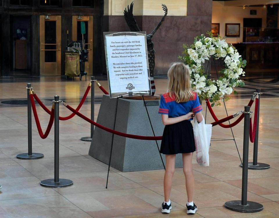 Elle Sandt, 8, of Parkville, stopped to view a memorial at Union Station Wednesday for the victims who died in the Amtrak train crash on Monday near Mendon, Missouri. The Amtrak Southwest Chief train crashed into a dump truck, killing four people and injuring dozens more.