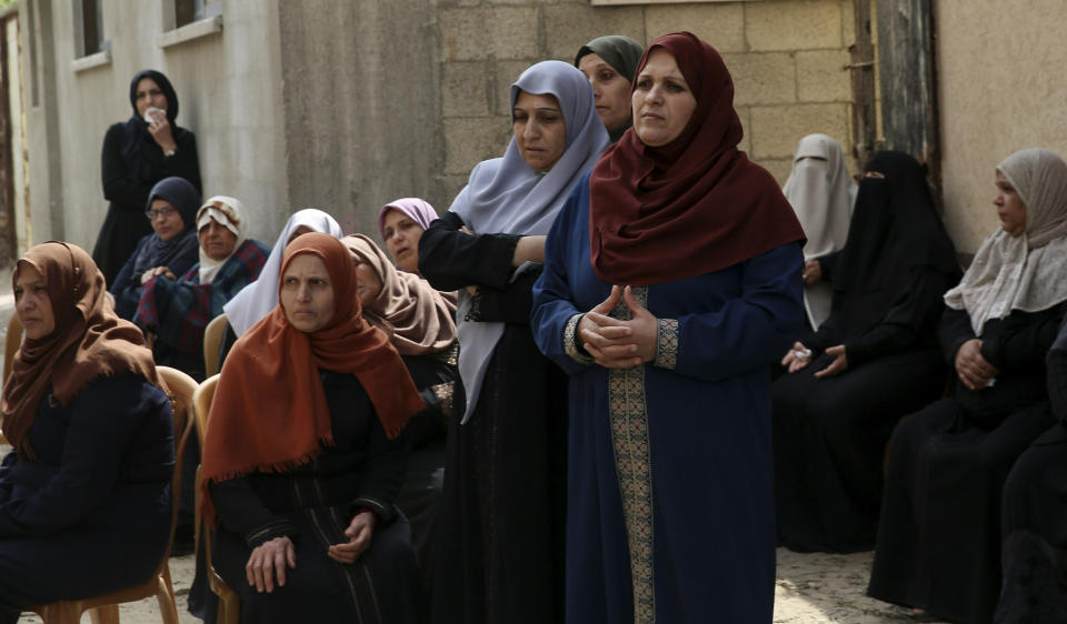 Relatives mourn while waiting for the body of Jihad Hararah, in front of his family house during his funeral in Shijaiyah neighborhood in Gaza City, Saturday, March 23, 2019. Gaza's Health Ministry said Hararah, died shortly after he shot at his face yesterday by Israeli troops during a protest at the Gaza Strip's border with Israel. (AP Photo/Adel Hana)