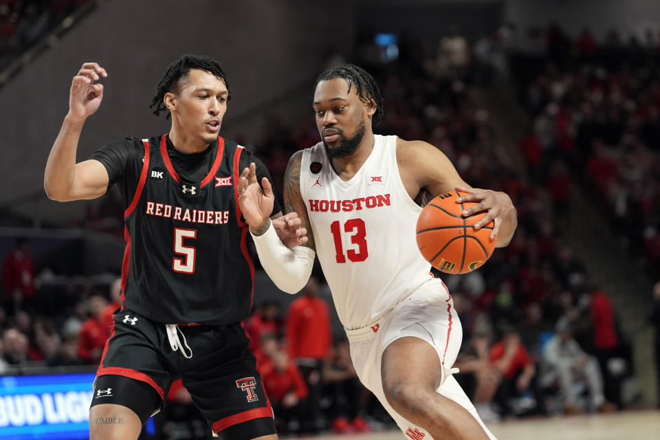 Houston's J'Wan Roberts (13) drives toward the basket as Texas Tech's Darrion Williams (5) defends during the second half of an NCAA college basketball game Wednesday, Jan. 17, 2024, in Houston. (AP Photo/David J. Phillip)