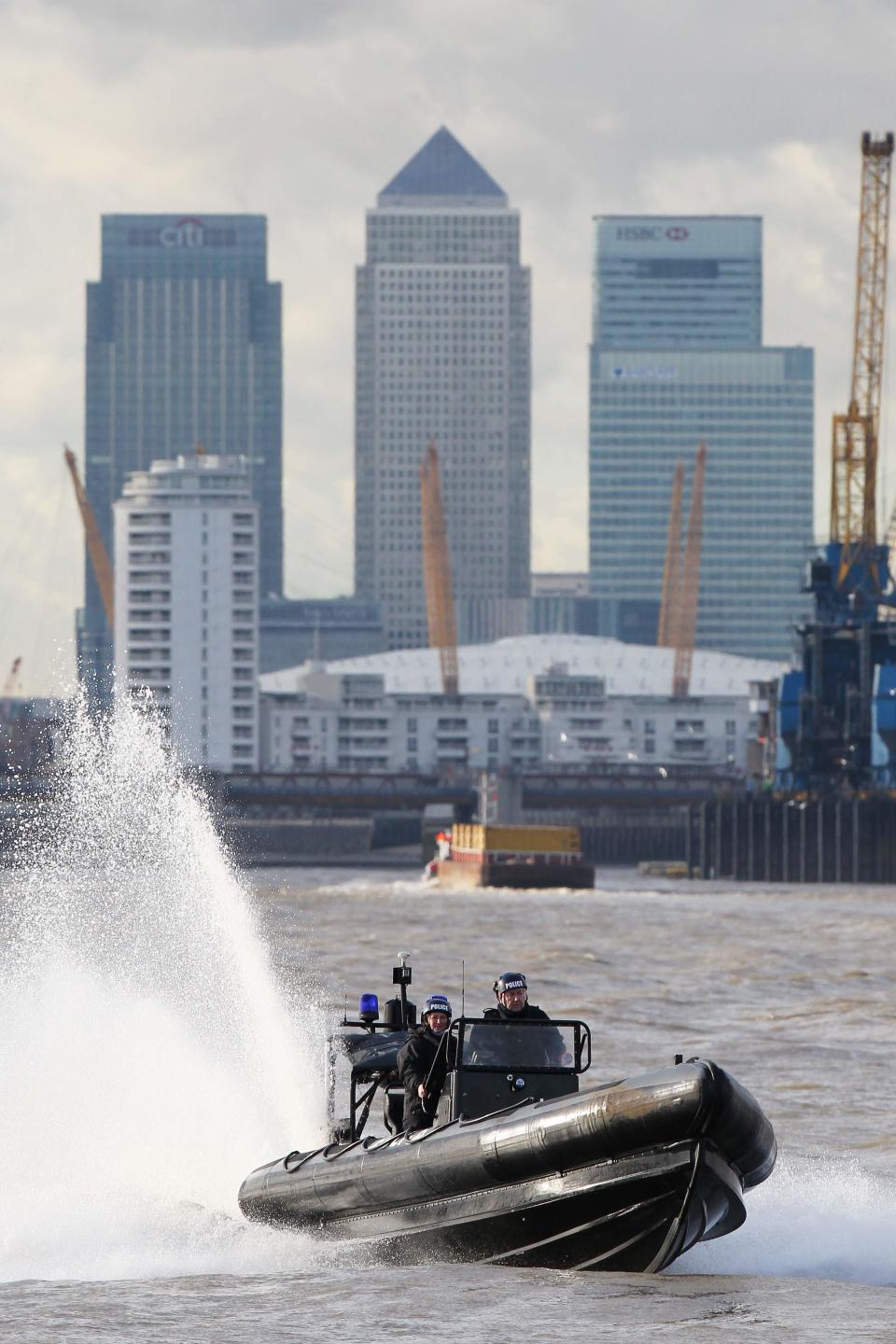 Members of the Metropolitan Police Marine Policing Unit (MPU) perform an exercise for the media on the River Thames in London January 19, 2012. The MPU have been training with Royal Marines from 539 Assault Squadron (539 ASRM) in preparation for providing security during the London 2012 Olympic Games.    REUTERS/Finbarr O'Reilly (BRITAIN - Tags: MILITARY POLITICS SOCIETY SPORT OLYMPICS)