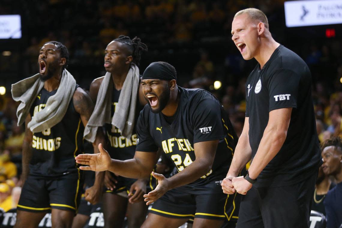 The Aftershocks bench cheers after a steal in the first Half against Bleed Green (North Texas Alumni) in The Basketball Tournament held at Koch Arena. At far right is the head coach of the Aftershocks, Zach Bush, a 2017 Wichita State grad who was a walk-on on the basketball team.