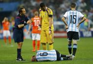 Argentina's Lucas Biglia (bottom) lies on the pitch following an injury after colliding with Daryl Janmaat (not seen) of the Netherlands during their 2014 World Cup semi-finals at the Corinthians arena in Sao Paulo July 9, 2014. REUTERS/Darren Staples (BRAZIL - Tags: SOCCER SPORT WORLD CUP)