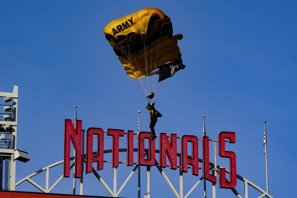 Un miembro del equipo de paracaidistas Golden Knights del Ejército de Estados Unidos desciende al National Park antes de un partido entre los Nacionales de Washington y los Diamondbacks de Arizona el miércoles 20 de abril de 2022, en Washington. (AP Foto/Alex Brandon)