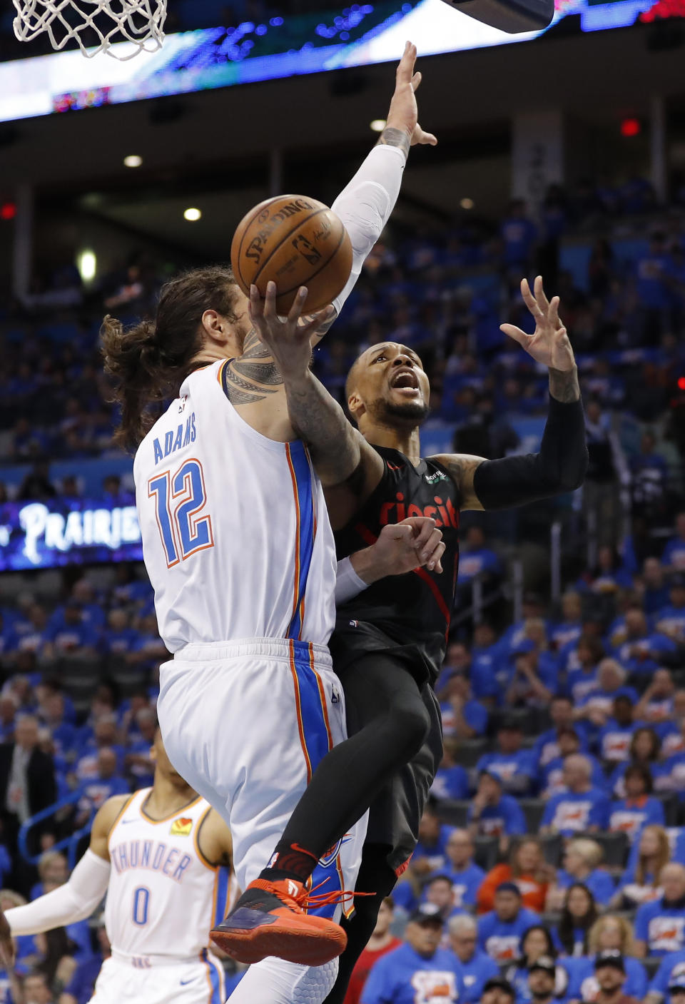 Portland Trail Blazers guard Damian Lillard (0) goes to the basket as Oklahoma City Thunder center Steven Adams (12) defends in the second half of Game 4 of an NBA basketball first-round playoff series Sunday, April 21, 2019, in Oklahoma City. Portland won 111-98. (AP Photo/Alonzo Adams)