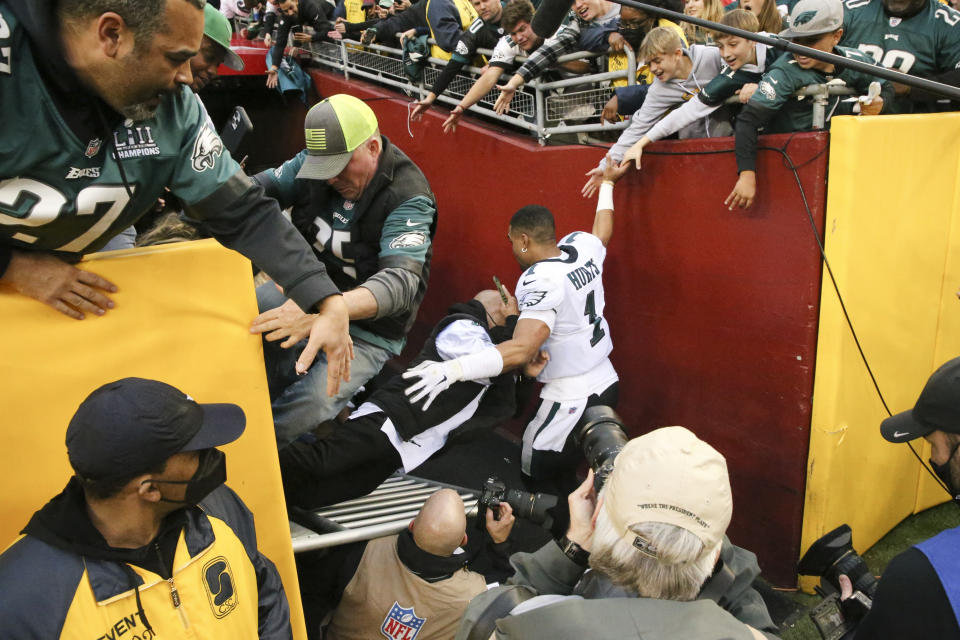 Fans fall on Philadelphia Eagles quarterback Jalen Hurts (1) after beating the Washington Football Team 20-16 on Sunday, January 2, 2022 in Landover, Maryland.(Shaban Athuman/Richmond Times-Dispatch via AP)