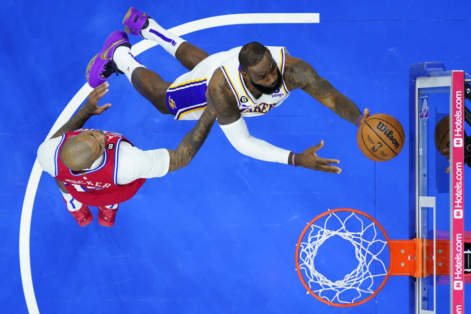 Los Angeles Lakers' LeBron James, right, goes up for a shot past Philadelphia 76ers' P.J. Tucker during the first half of an NBA basketball game, Friday, Dec. 9, 2022, in Philadelphia. (AP Photo/Matt Slocum)