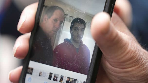 PHOTO: Paul Ventura, father of 18-year-old Mateo Ventura, both of Wakefield, Mass., displays a photograph on his cell phone that shows what he describes as a photo of himself and his son Mateo, right. (Steven Senne/AP)