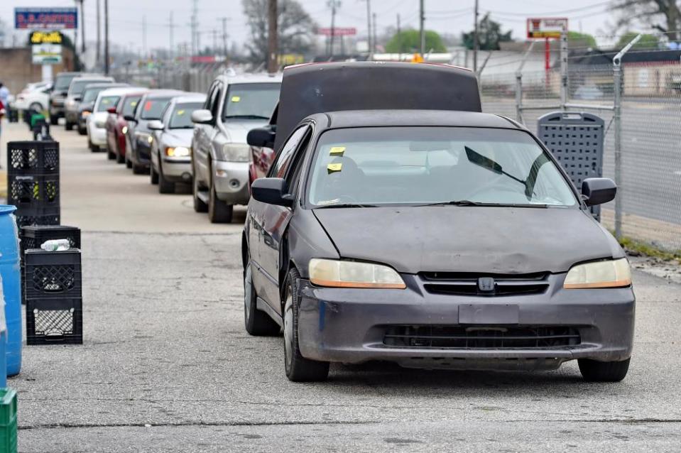 Cars line up for groceries at a drive-thru and pick up location at Harvest Hope Food Bank Wednesday, March 18, 2020, in Greenville, S.C. Harvest Hope helps low income families and senior citizens. (AP Photo/Richard Shiro)