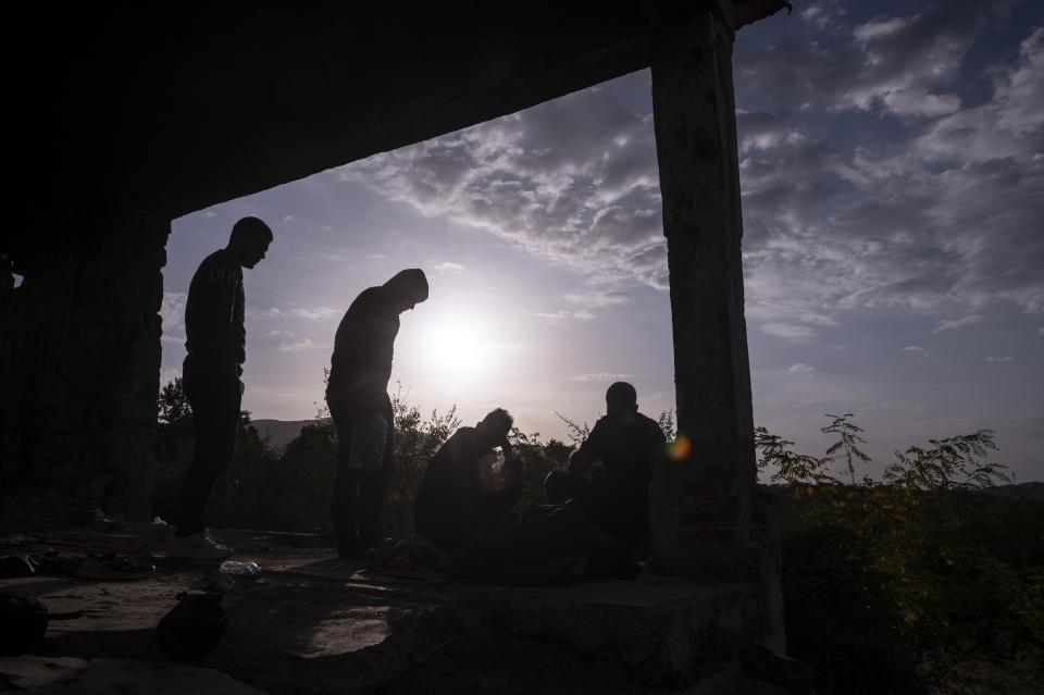 Syrian migrants gather outside an abandoned army outpost near Ieropigi village, northern Greece, at the Greek - Albanian border, on Tuesday, Sept. 28, 2021. A relatively smooth section of Greece's rugged border with Albania is turning into a major thoroughfare north for migrants in Greece seeking a better life in Europe's prosperous heartland. (AP Photo/Giannis Papanikos)