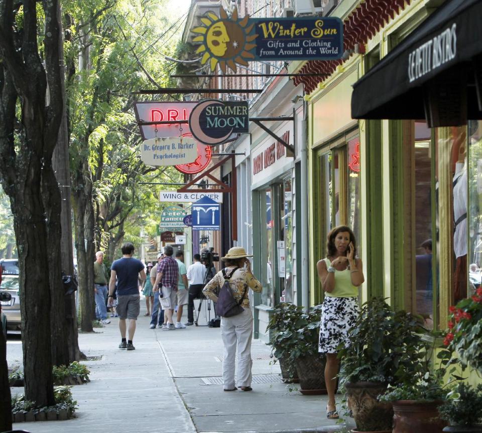 FILE - This July 28, 2010 file photo shows people along East Market Street in Rhinebeck, N.Y. A number of once-sleepy Hudson Valley towns have been gentrified over the decades thanks to an influx of second-homeowners from New York City. Rhinebeck is essentially a one-stoplight town with a concentration of stores and restaurants packed around the intersection. (AP Photo/Mike Groll, File)