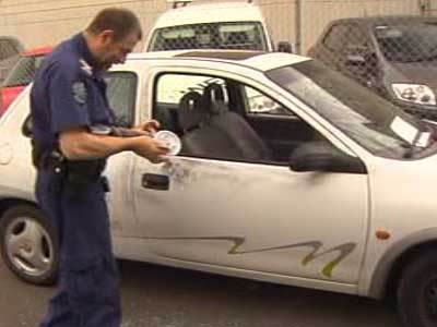 <p>A crime scene investigator dusts for prints on one of the vehicles.</p>