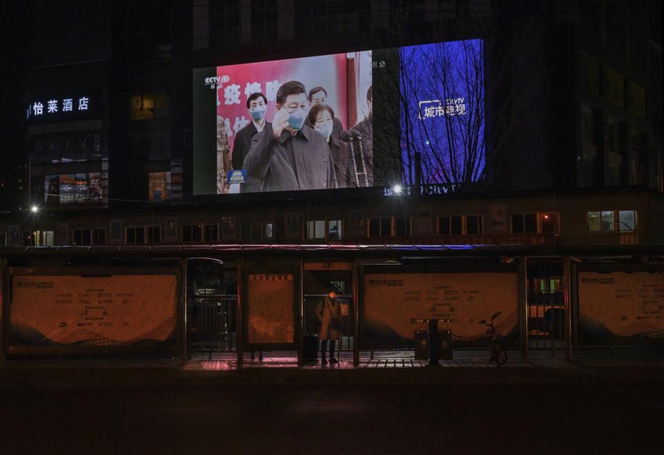 A TV screen shows images of President Xi Jinping visiting Wuhan, China, on March 10, 2020.