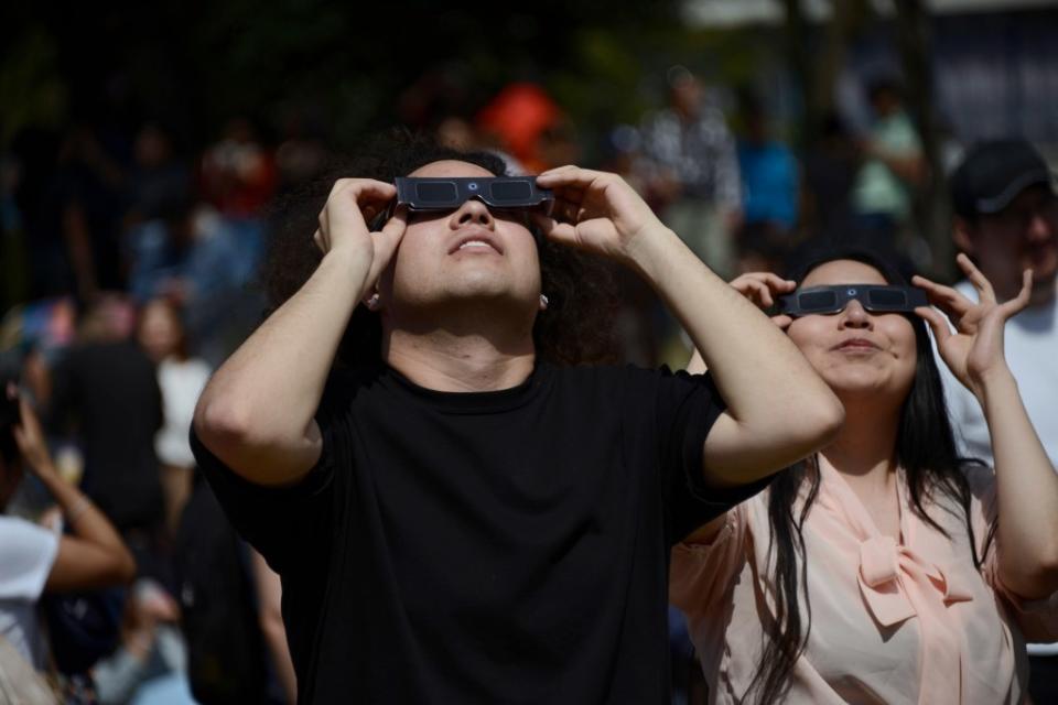 A couple is seen observing the annular solar eclipse with special filter glasses for the sun at the National Autonomous University of Mexico. Future Publishing via Getty Images