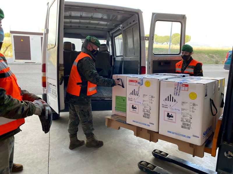 FILE PHOTO: Military personnel carry boxes of Pfizer-BioNtech COVID-19 vaccine after arriving at a warehouse in Colmenar Viejo