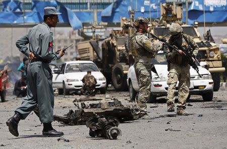 NATO troops investigate at the site of a suicide car bomb attack in Kabul August 10, 2014. REUTERS/Omar Sobhani