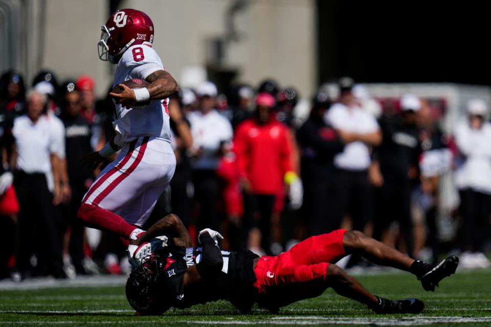 Oklahoma Sooners quarterback Dillon Gabriel (8) is dragged down by Cincinnati Bearcats safety Ken Willis (27) in the second quarter of the NCAA Big 12 football game between the Cincinnati Bearcats and the Oklahoma Sooners at Nippert Stadium in Cincinnati on Saturday, Sept. 23, 2023.