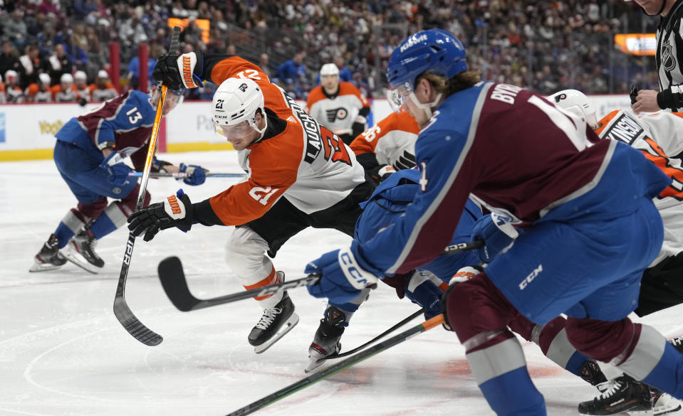 Philadelphia Flyers center Scott Laughton, back, races to the puck with Colorado Avalanche defenseman Bowen Byram, right, in the second period of an NHL hockey game Saturday, Dec. 9, 2023, in Denver. (AP Photo/David Zalubowski)