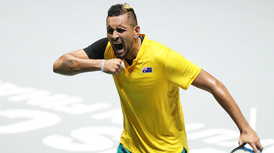 Nick Kyrgios pumps his chest as he celebrates after winning his tie against Belgium.