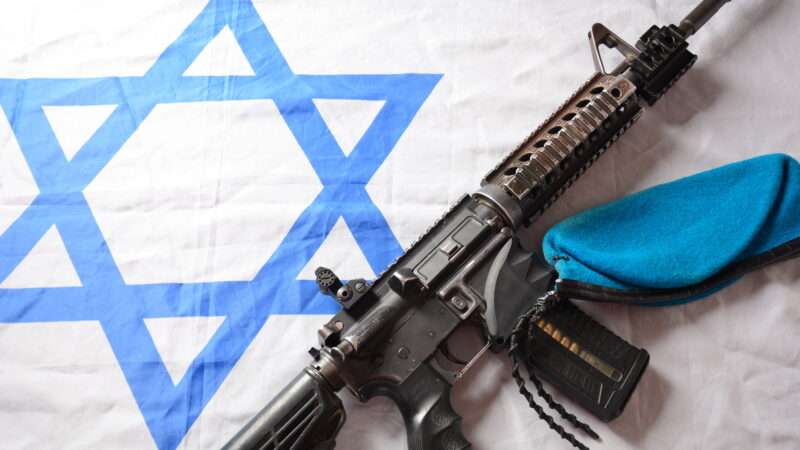 An M4 carbine against an Israeli flag.