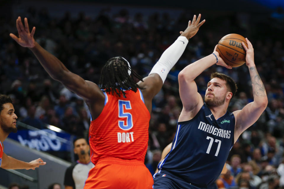 Dallas Mavericks guard Luka Doncic (77) attempts to shoot as Oklahoma City Thunder forward Luguentz Dort (5) defends during the first half of an NBA basketball game, Monday, Jan. 17, 2022, in Dallas. (AP Photo/Brandon Wade)