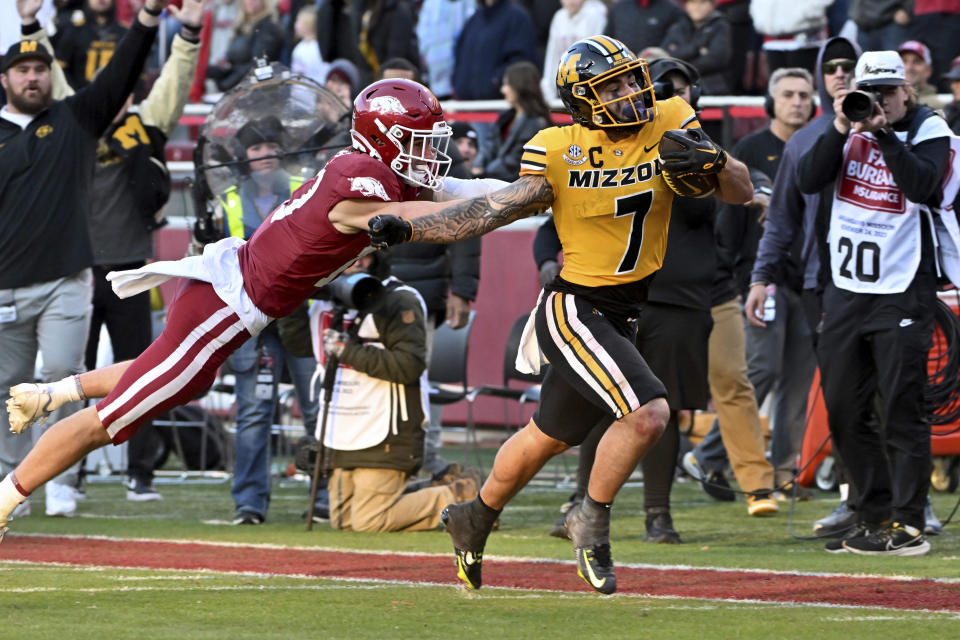 Missouri running back Cody Schrader (7) is knocked out of bounds by Arkansas defensive back Hudson Clark (17) during the second half of an NCAA college football game Friday, Nov. 24, 2023, in Fayetteville, Ark. (AP Photo/Michael Woods)