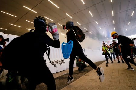 Anti-extradition bill protesters throw bricks as they clash with riot police during a march in Hong Kong