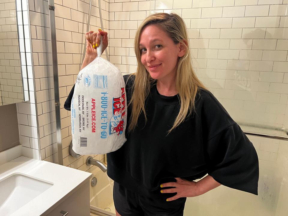 jen holding up a bag of ice in front of her shower