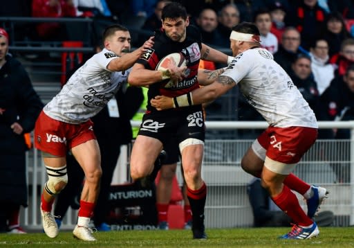 Toulon's Anthony Meric and Raphael Lakafia close in on Xavier Mignot, one of the Lyon try scorers