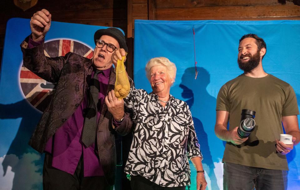 Keith Fields, left, Marlene Appledorn, middle and Josh Sperling stand in front of a large audience as Keith performs a magic trick during the Magic Soiree inside Camp Ticonderoga in Troy on Saturday, Sept. 30, 2023.