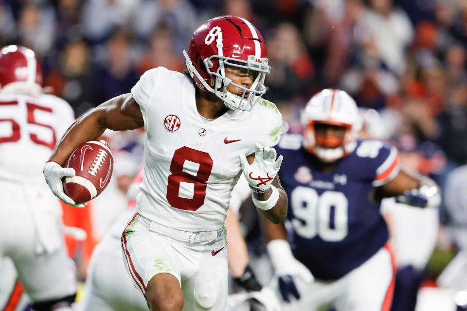 Alabama wide receiver John Metchie III (8) carries the ball against Auburn during a game on Nov. 27, 2021, in Auburn, Ala.